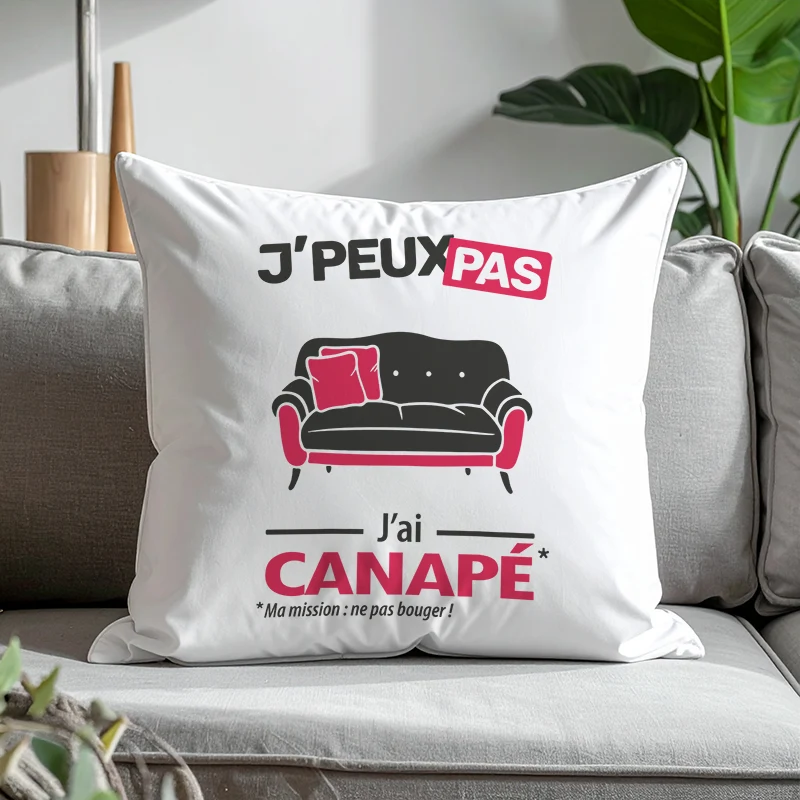 Coussin 'Je peux pas j’ai canapé' imprimé en cadeau et posé sur un divan